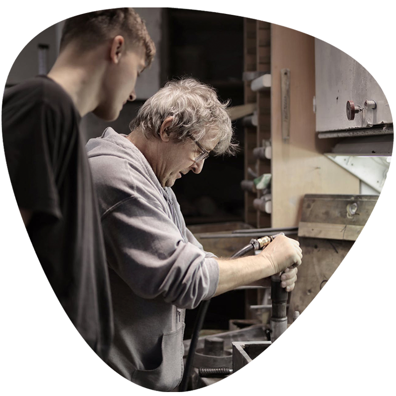 Older man teaching youth manufacturing